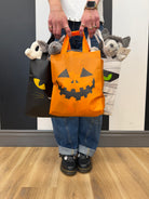 photo of woman holding 3 halloween baskets filled with halloween items