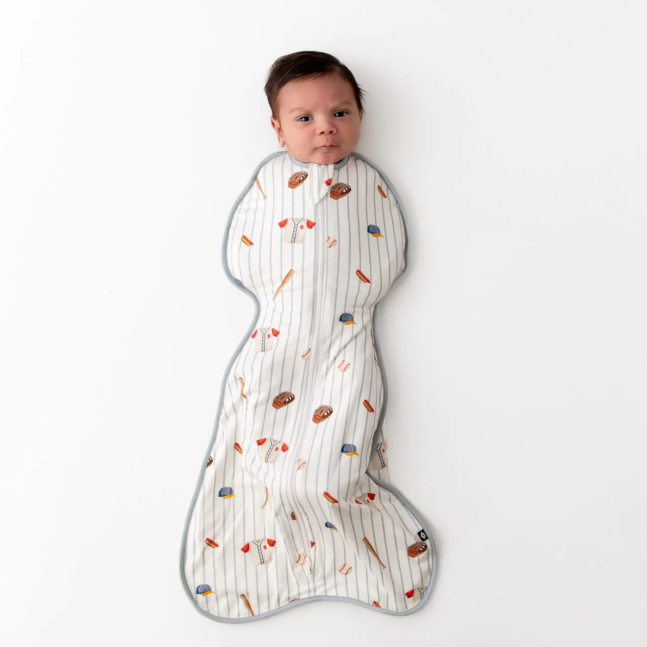 Baby wrapped in a baseball patterned swaddle on a white background
