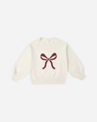 White sweater with a red bow design on a white background