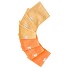 A stack of folded washcloths in orange and yellow shades, with a brand tag visible on them.
