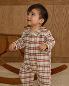 Baby in a plaid romper with snap buttons down the front