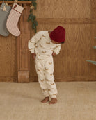 Child wearing white sweatpants with a Christmas dog pattern 