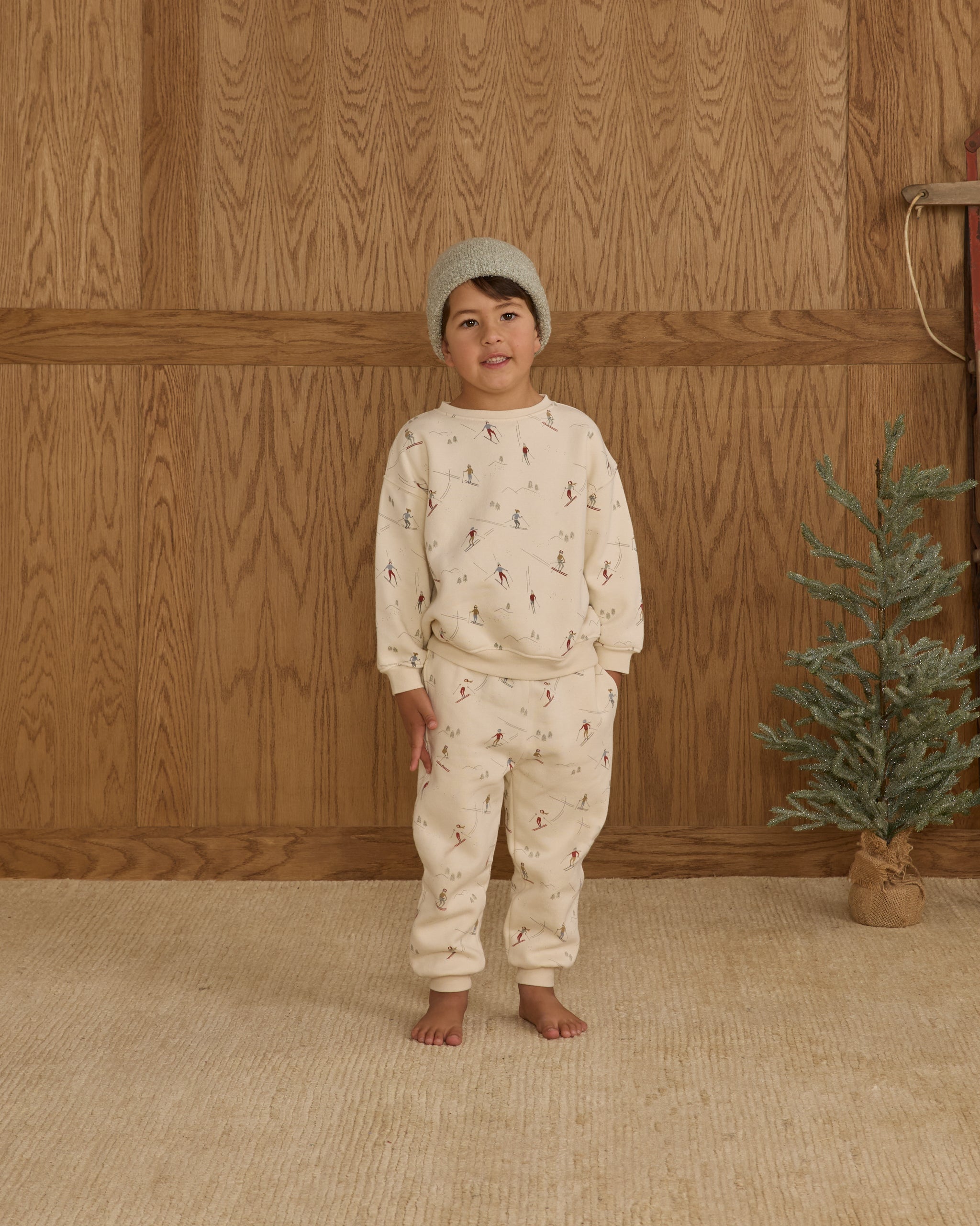 Child wearing white sweatpants with a ski pattern