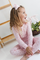 Young girl in pink pajamas with a pink floral design. 