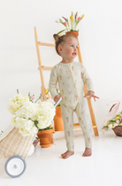Child in a light-colored onesie with a floral pattern