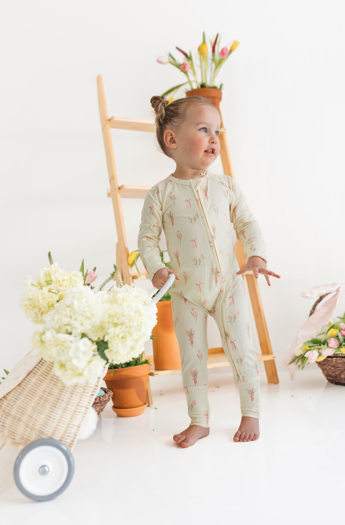 Child in a light-colored onesie with a floral pattern