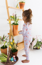 Child in floral pajamas with purple and white stripes