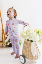Child in floral pajamas with white and purple stripes. 