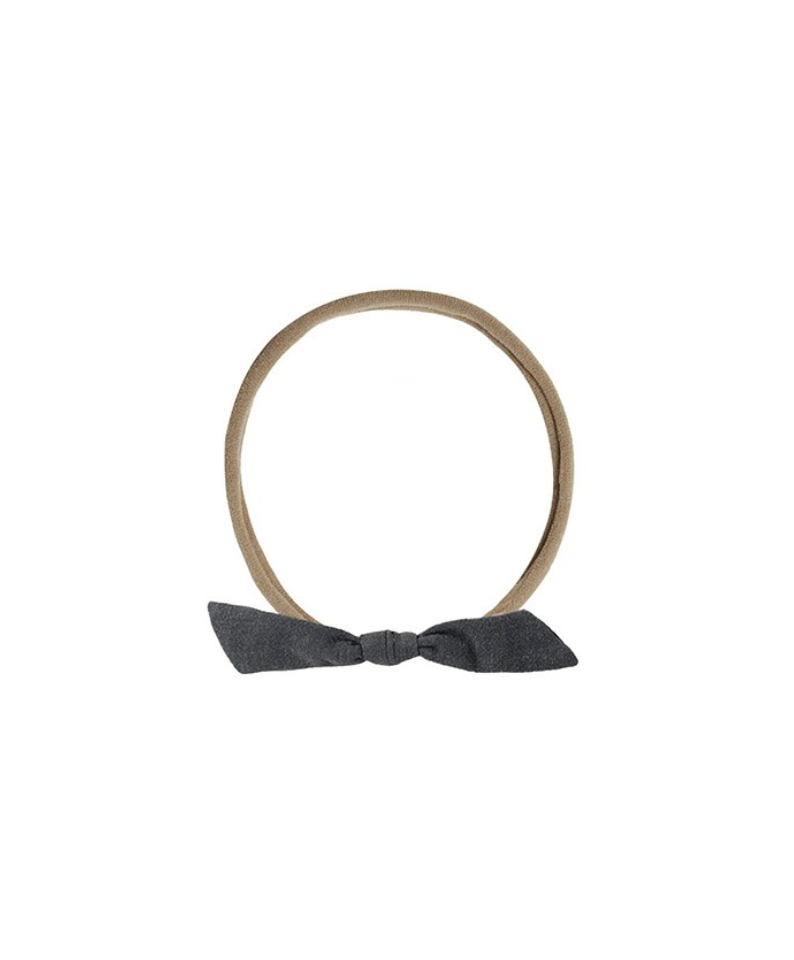 Tan elastic headband with a dark gray bow on a white background