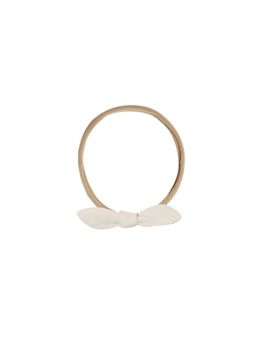 A light brown elastic headband with a small white fabric bow at the front, shown on a plain white background.