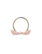 A light pink fabric bow headband with a tan elastic band, shown against a plain white background.