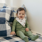 toddler in green pajamas and western bandana bib