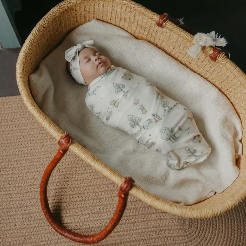 baby in hundred acre woods poo swaddle with matching bow 