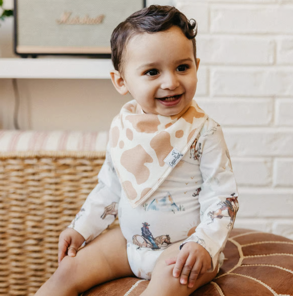 baby wearing cow print bandana bib