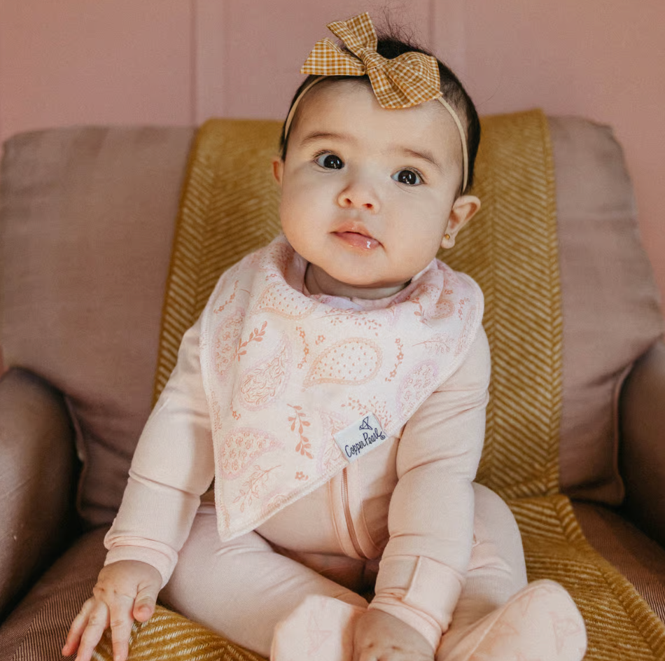 baby with bow wearing a bandana bib