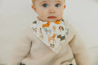 baby wearing bandana bib with a print of various dogs 
