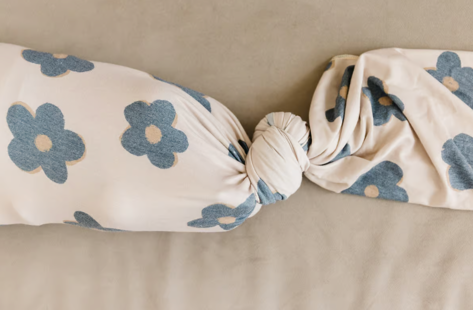 beige and black floral swaddle blanket with tie knot