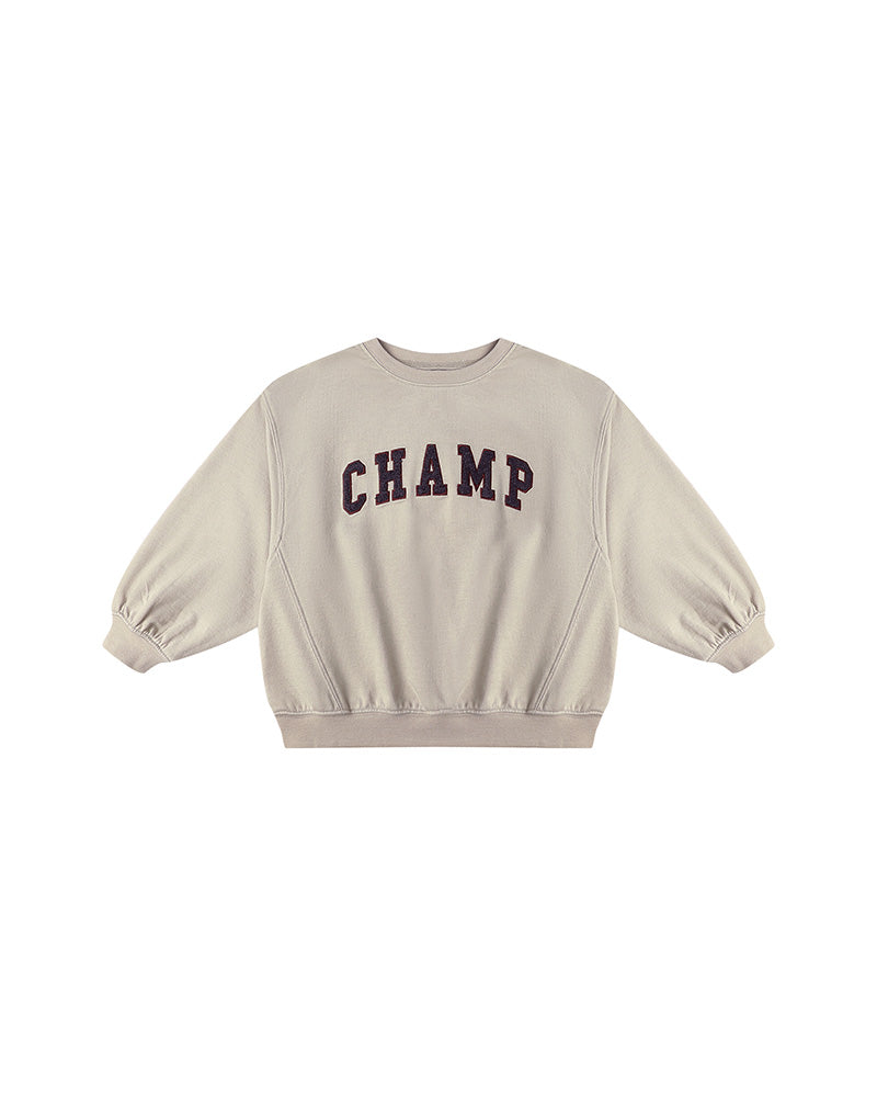 Beige sweatshirt with 'CHAMP' text on a white background