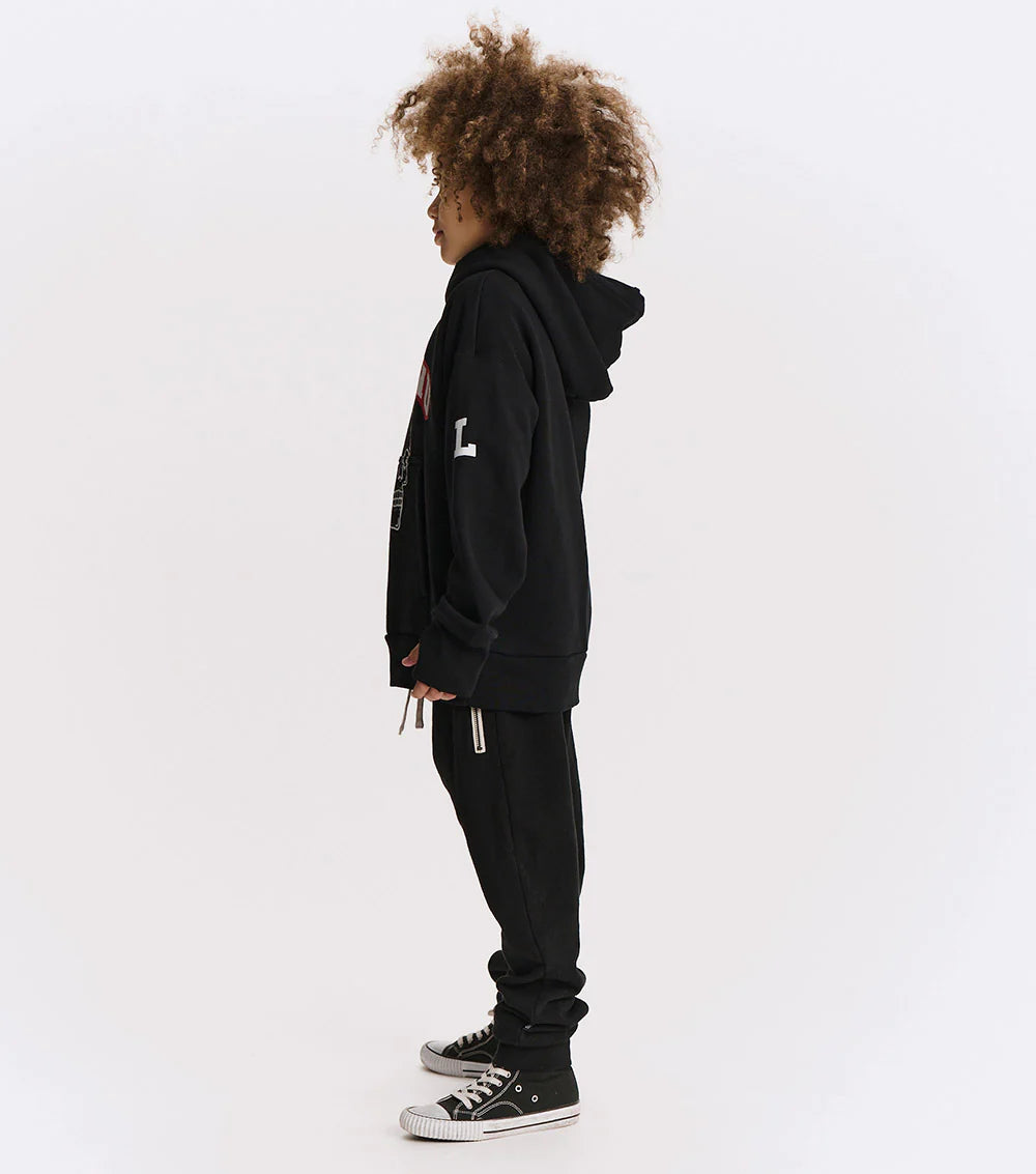 Person wearing a black hoodie and pants on a white background