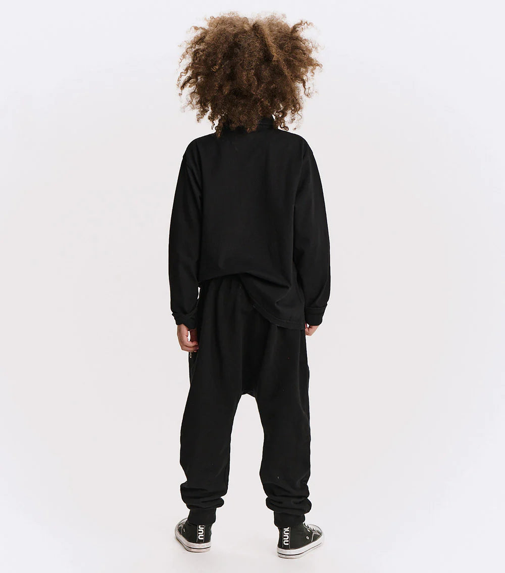 Person wearing a black tracksuit on a white background