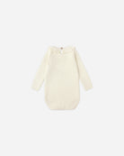 Cream-colored baby outfit with long sleeves on a white background