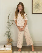 Young girl wearing a matching holiday set with candy cane details. 