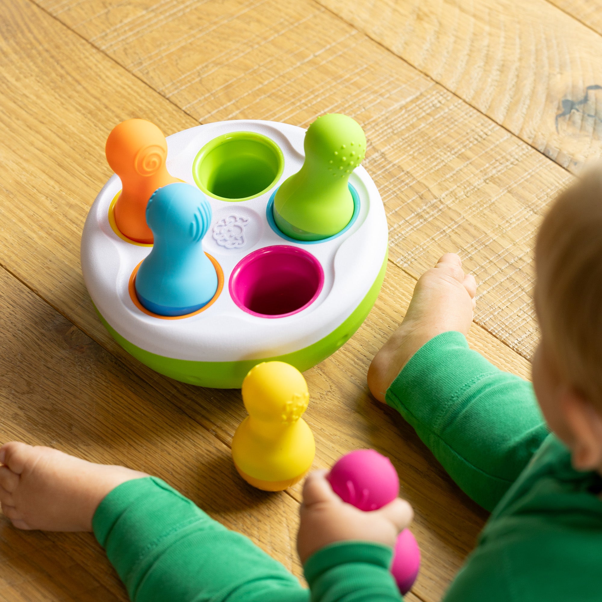 SpinnyPins toy by Fat Brain with five colorful spinning pins and weighted bowl