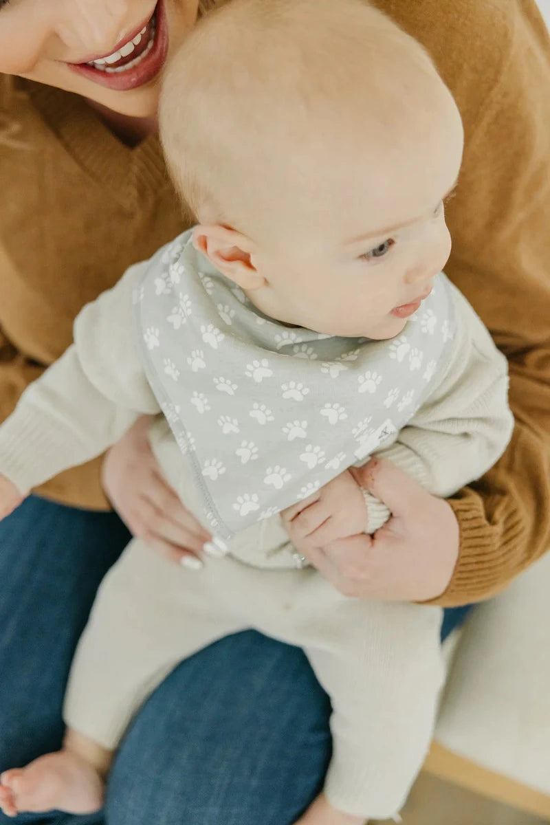 baby wearing bandana bib with paw prints 