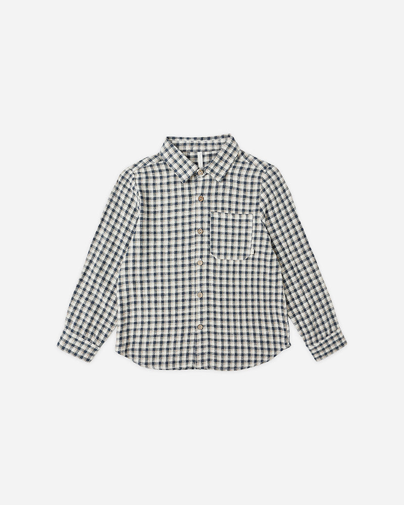 navy and cream plaid button up shirt against a white background 