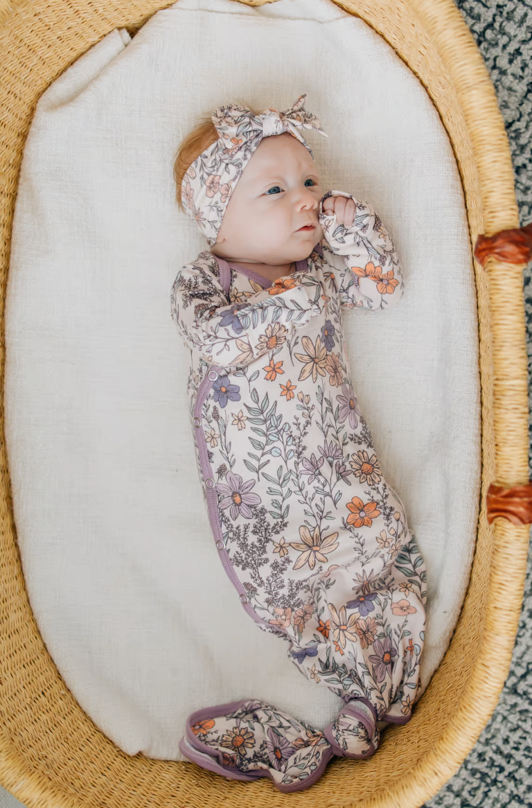 newborn in purple floral knotted gown 