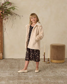 Young girl in a beige collared furry coat 