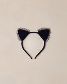 Black cat ear headband with tulle on a beige background