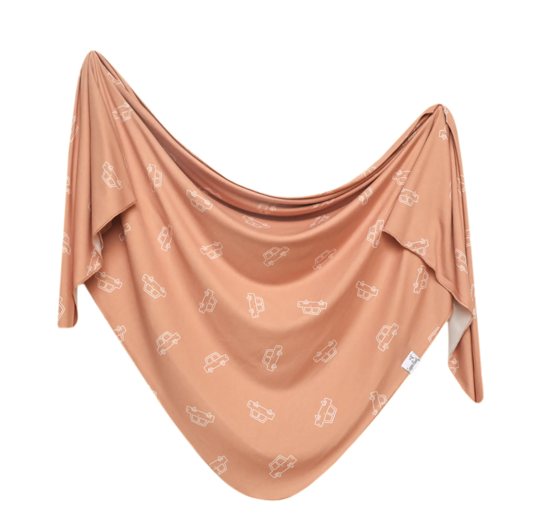 orange swaddle blanket with white truck pattern 