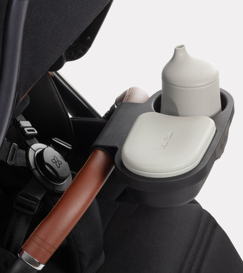 Stroller organizer with cup holder, bottle, and pouches inside a stroller.