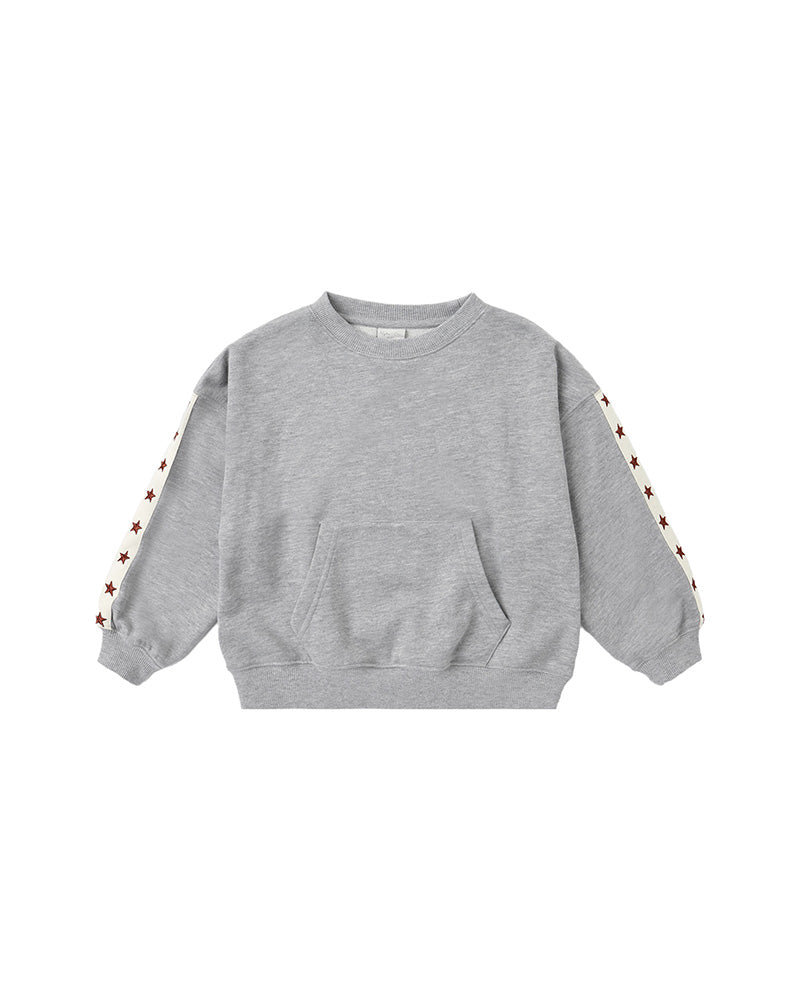 A light gray heather crewneck sweatshirt with a front kangaroo pocket and decorative white stripes on the sleeves featuring small red star details, shown on a plain white background.