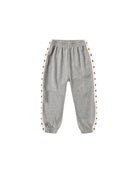 A pair of heather gray jogger sweatpants with white side stripes featuring a repeating red star pattern, shown against a plain white background.
