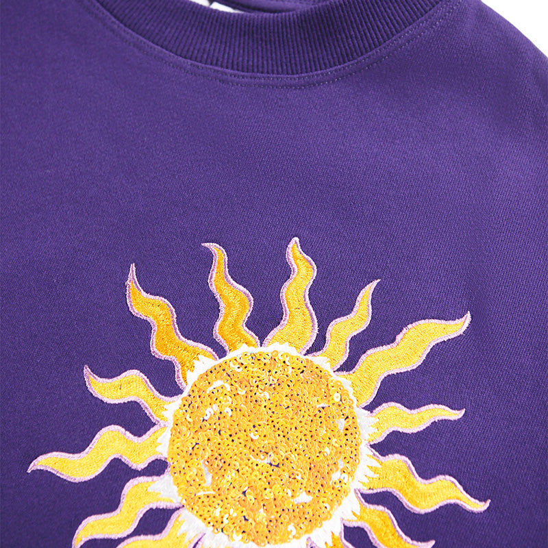 Purple sweatshirt with a yellow sun design on a white background