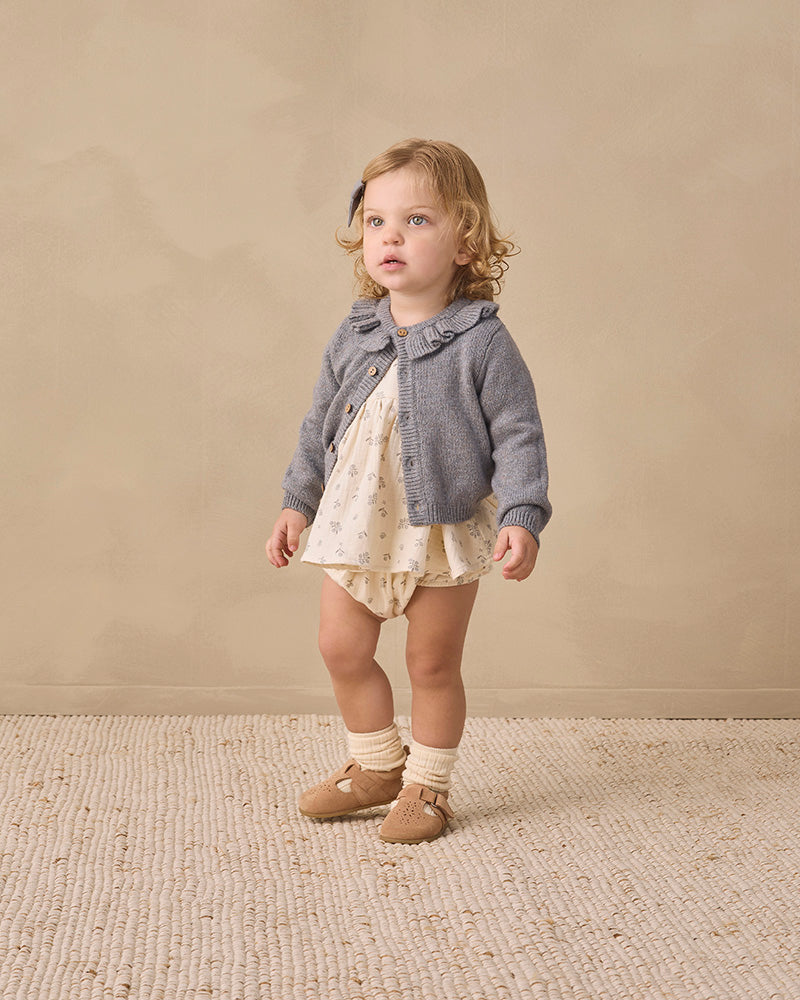 A gray knit cardigan sweater for toddlers, featuring a ruffled Peter Pan collar, long sleeves, and brown wooden buttons down the front, displayed on a clean white background.
