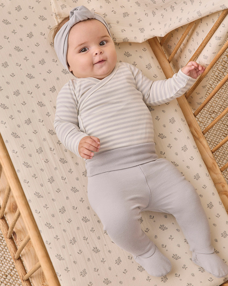 A baby clothing set featuring a long-sleeve wrap bodysuit with thin gray and white horizontal stripes, paired with light gray footed pants, shown on a plain white background.