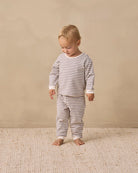 A two-piece children's outfit set featuring a long-sleeve top and matching pants, both with horizontal gray and off-white stripes, laid flat on a white background.