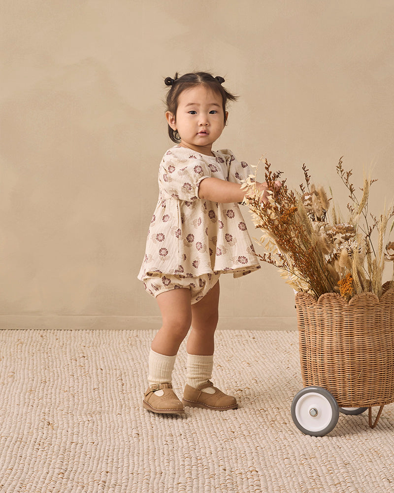 A baby girl's two-piece outfit set featuring a short-sleeve smocked blouse with puff sleeves and a matching bloomers diaper cover, both in an off-white fabric with a brown floral pattern, shown on a plain white background.