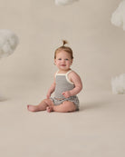 Baby in blue and white striped two piece set with white trim and ruffle details