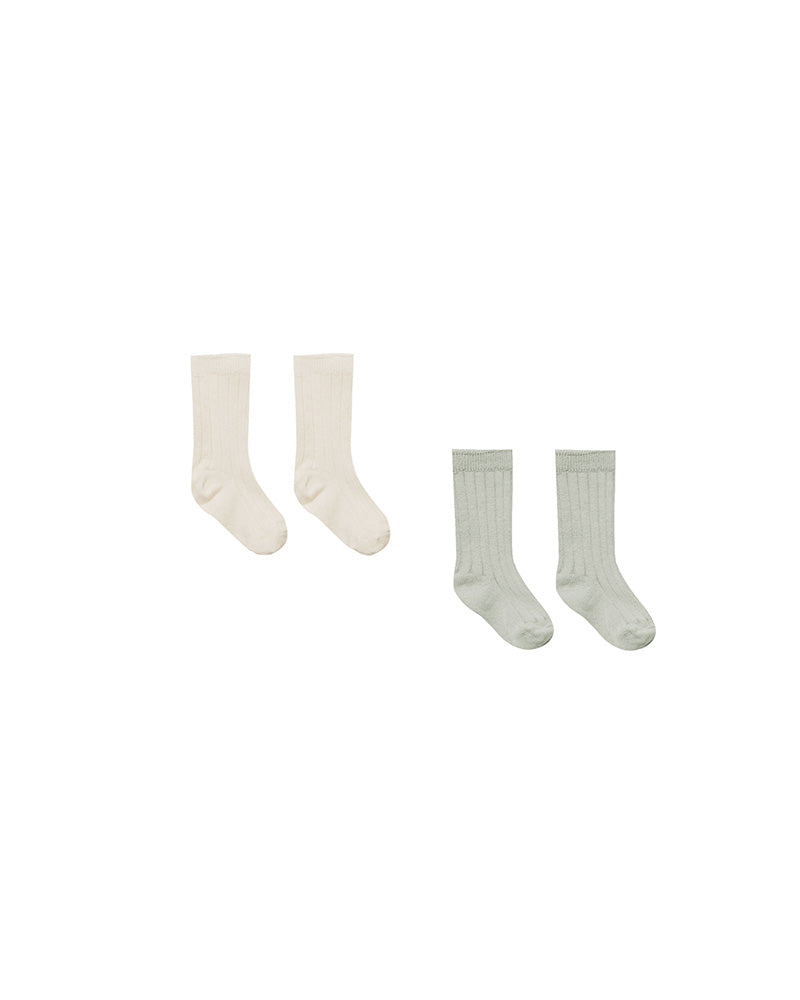 Two pairs of socks, one cream and one light green, on a white background.