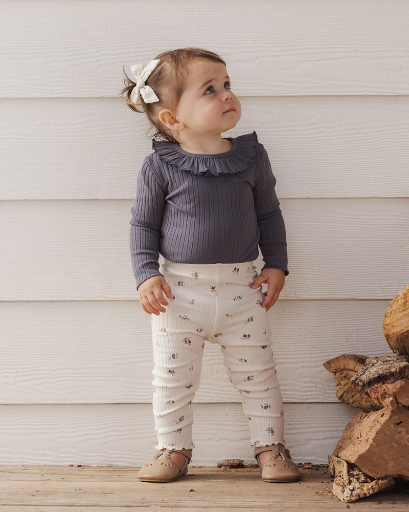 Dark gray ribbed baby bodysuit with ruffled collar on a white background
