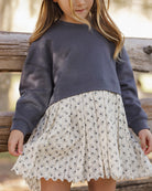 Two-tone dress with dark gray long sleeve top and floral patterned skirt on a white background