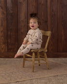 Children's pink outfit with dark pink floral pattern on a white background