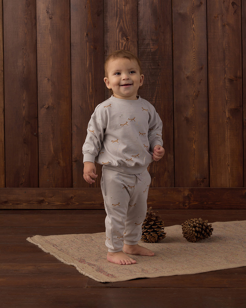 Light gray sweatpants with small fox pattern and a drawstring on a white background