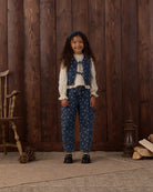 Denim vest with floral pattern and a bow tie front with pockets on a white background