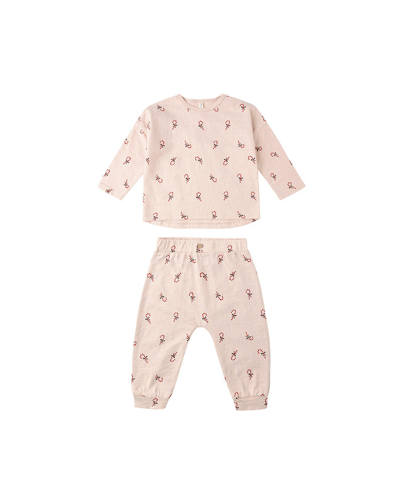 Pink children's pajama set with a candy-cane pattern on a white background