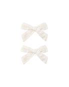 Two white bow clips on a white background